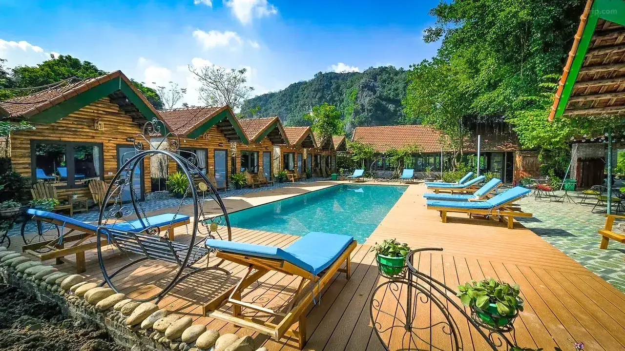 Outdoor pool surrounded by limestone mountains at Tam Coc Holiday Retreat, Vietnam